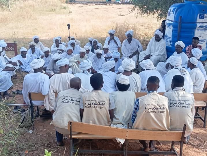 أفراد من المجتمع ومتطوعو لجنة سلام برام يجلسون معاً في لقاء مفتوح